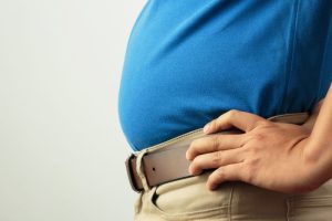 お腹が出ているのを気にする男性