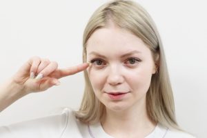目の下のクマについて説明する看護師