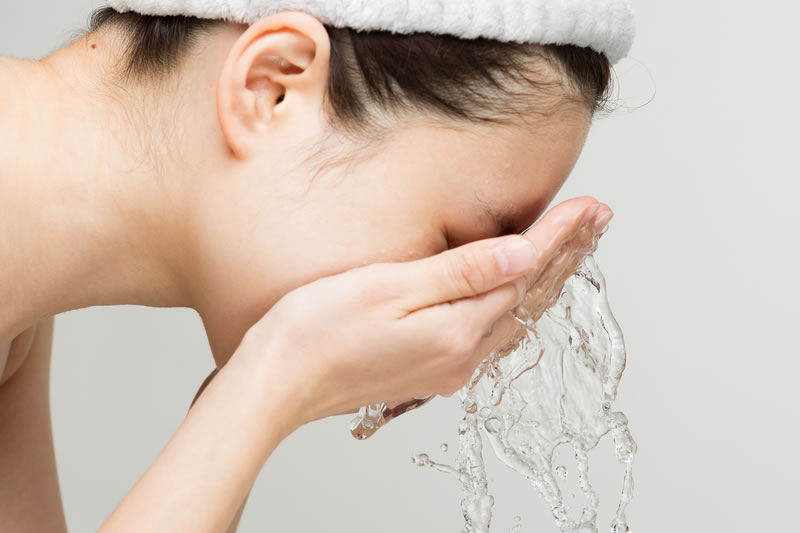 顔の自己処理のあとに洗顔をしている女性