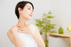 デコルテに手を当てている女性