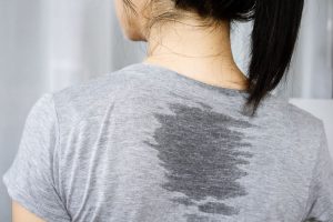 グレーのTシャツの背中に、汗でぬれて色が濃くなったところがある