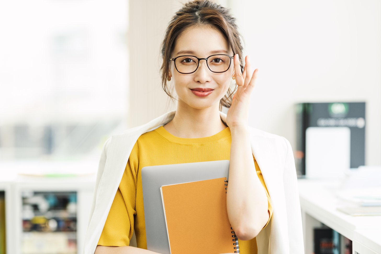 オフィスで書類を持つ女性。二重整形後に仕事へ復帰する時期のイメージ