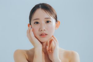 不安そうな表情で頬に手を当てる女性。美容整形後の経過に不安を感じている様子