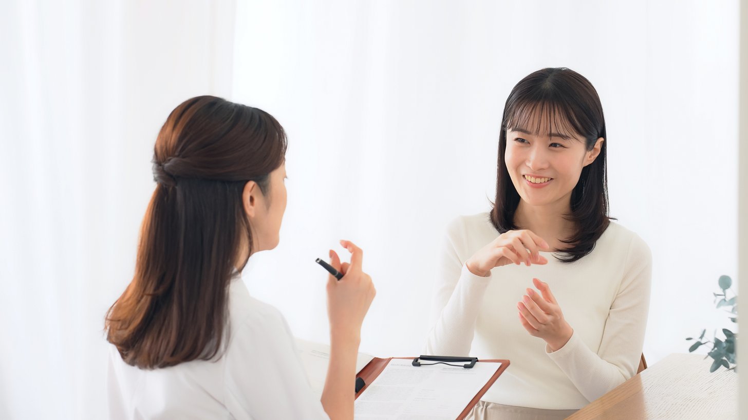 患者が医療スタッフに症状を伝えている様子