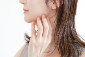 あごから頬のラインに指を添える女性の横顔。糸リフトで引き上げるフェイスラインのイメージ
