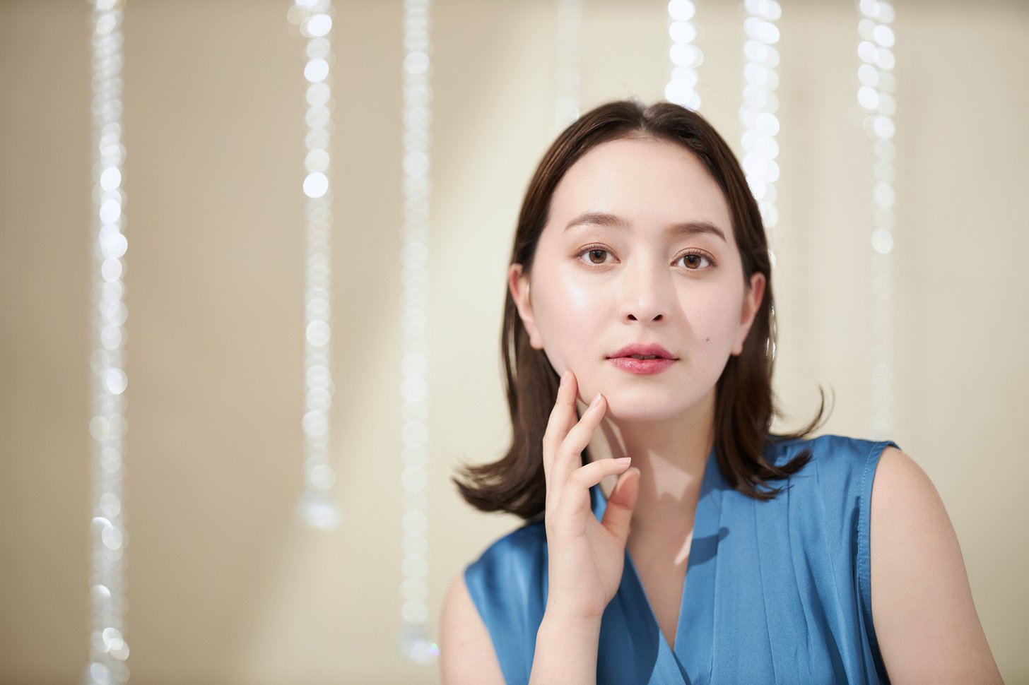 頬に手を当てて表情を確かめる女性。糸リフト後の腫れやむくみを気にしている様子