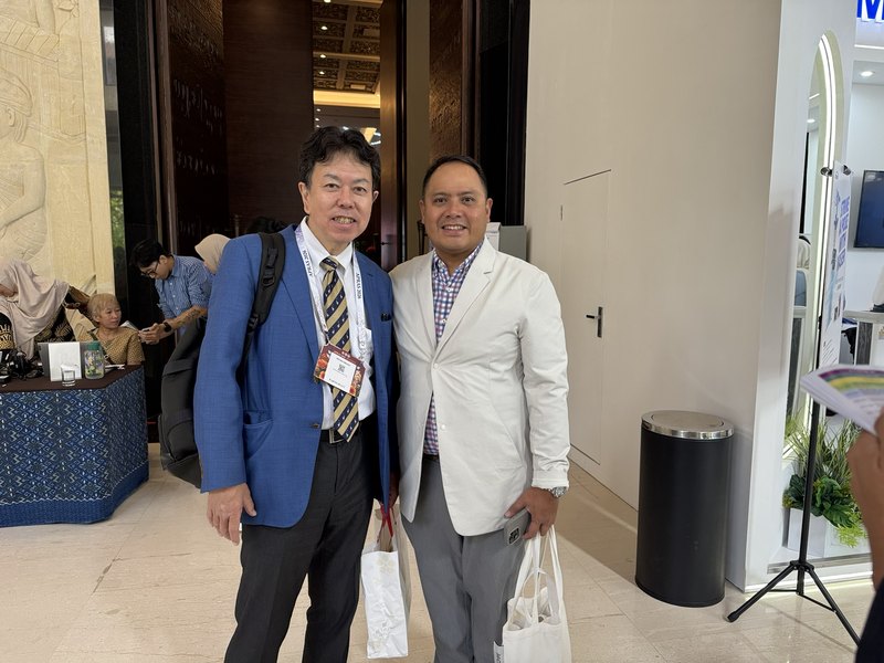 APRAS 2026の会場で海外の形成外科医と写る水野博司医師