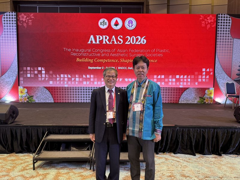 APRAS 2026の会場で海外の形成外科医と写る水野博司医師