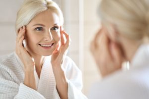 鏡を見てシワを気にする女性