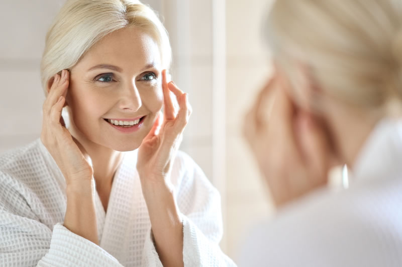 鏡を見てシワを気にする女性