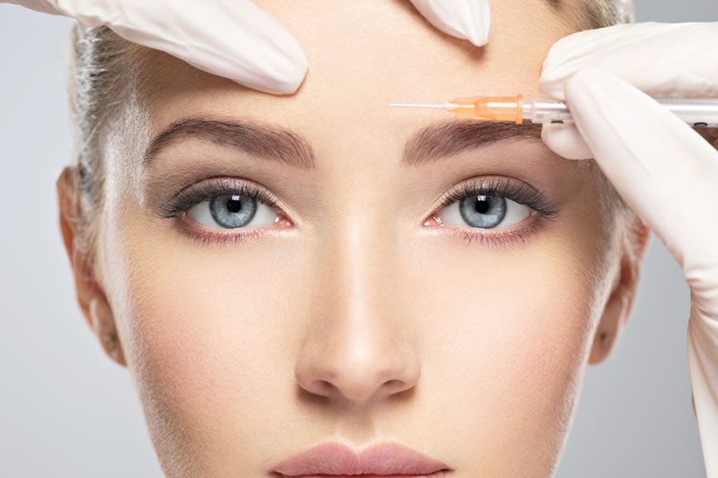 おでこにボトックスを注射している女性