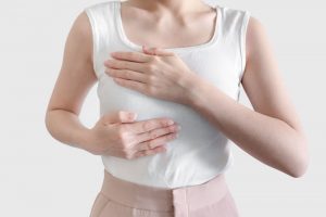胸を手で強調している女性
