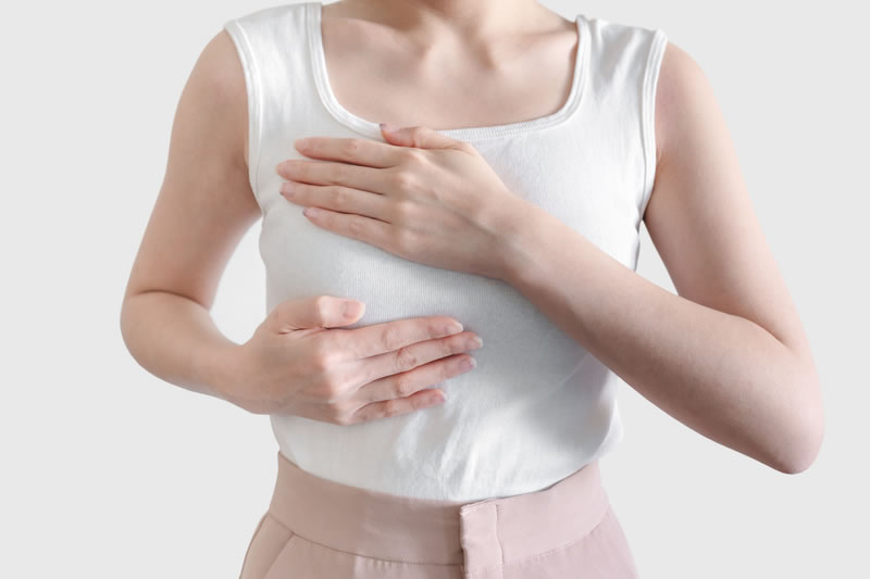 胸を手で強調している女性