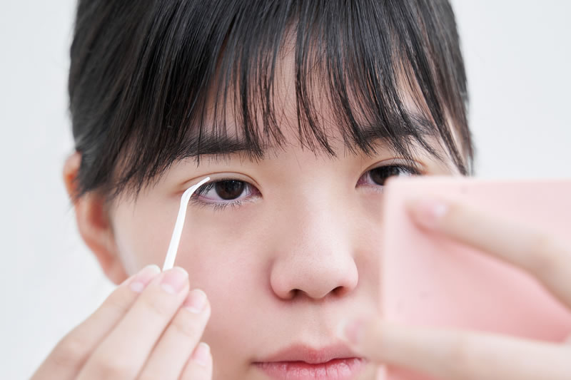 アイプチで二重まぶたをつくっている女性