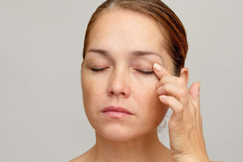 まぶたに手を当てている女性