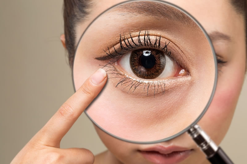 目尻を指さす女性